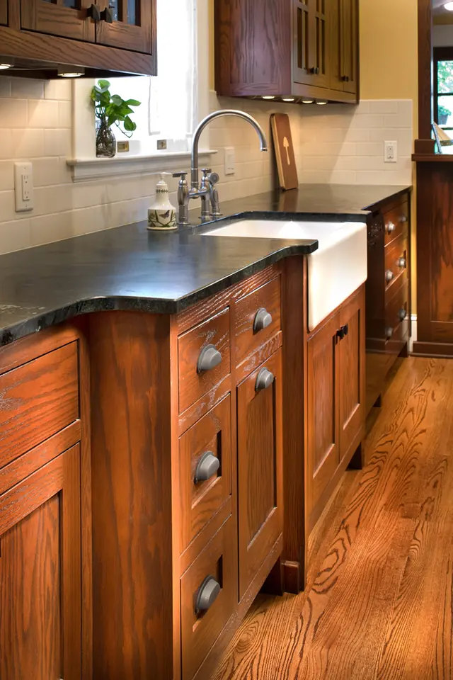 Custom curved wood island with apron-front sink in a remodeled kitchen